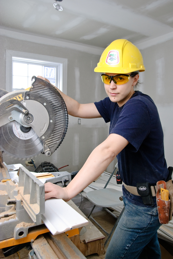 Handwerkerin mit Kappsäge bei Ausbauarbeiten